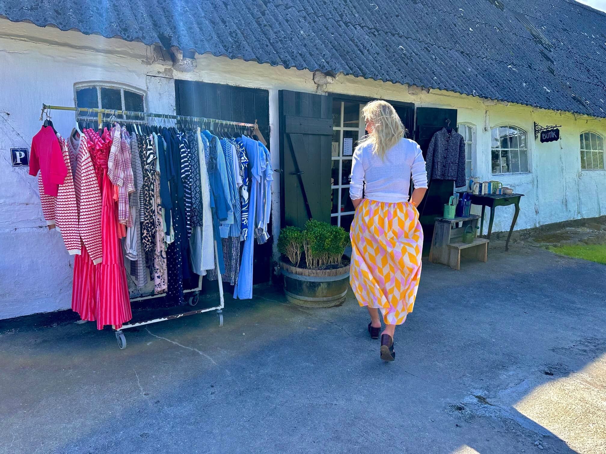 Facaden hos Himmel & Hav med tøjstativer udenfor og skiltet Butik