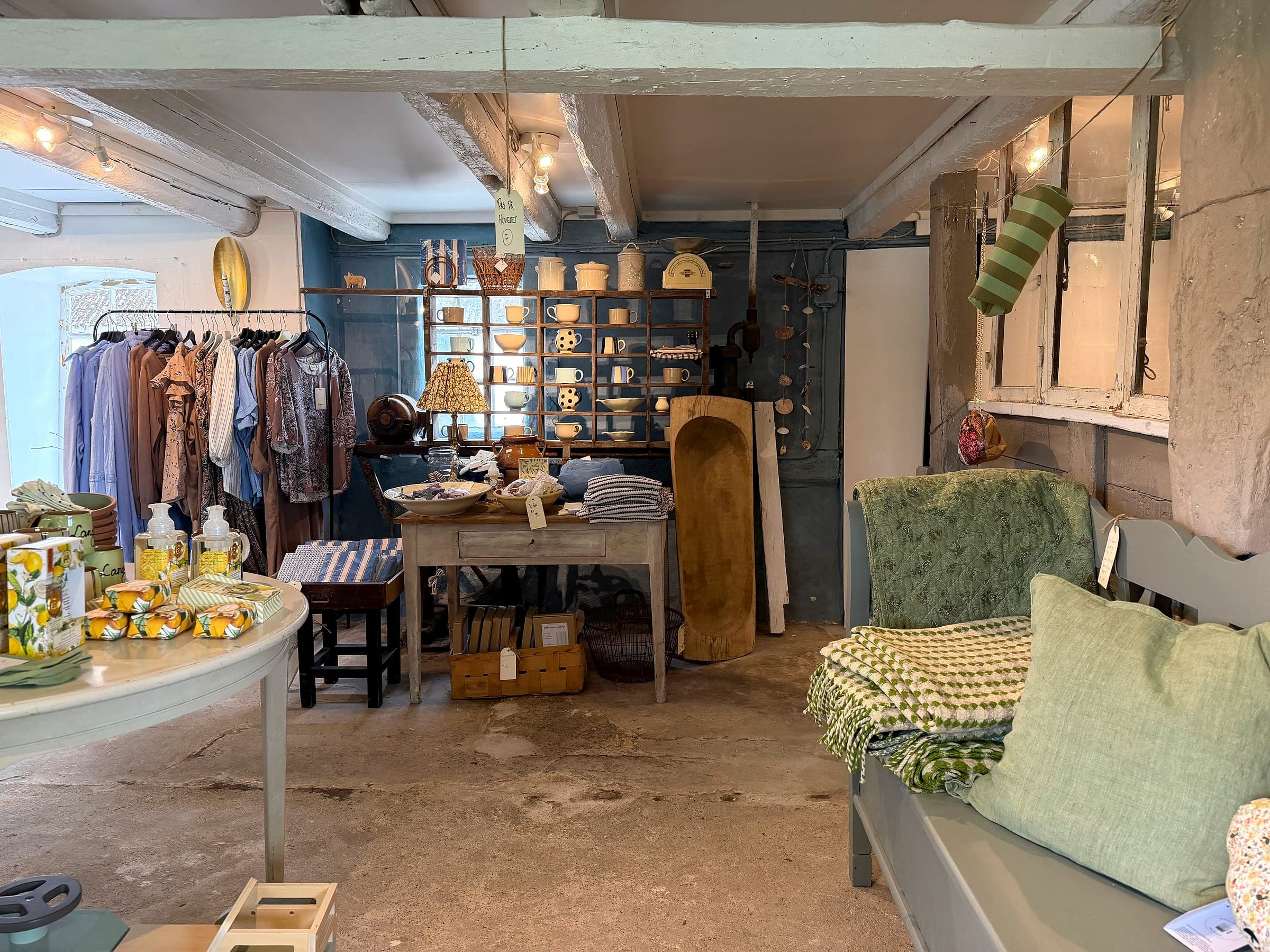 Hjørne i butikken med krukker, kopper og skåle på reoler