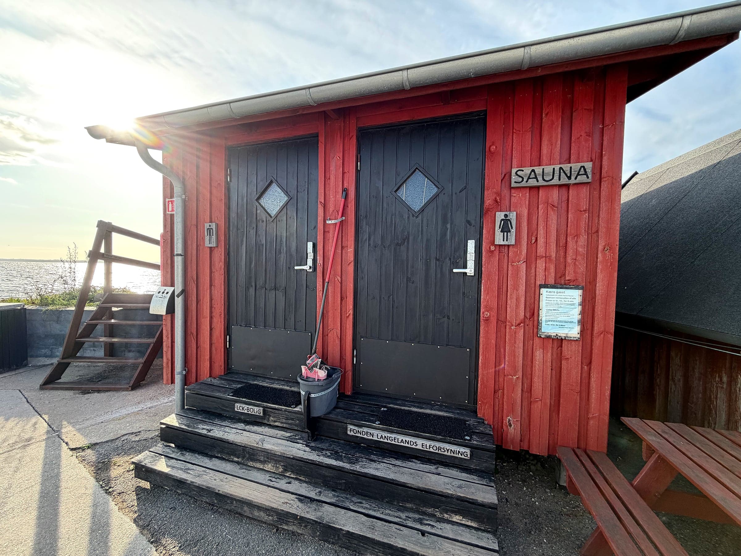 Den røde saunahytte ved Lohals Havn med skiltet Sauna og separate døre til mænd og kvinder