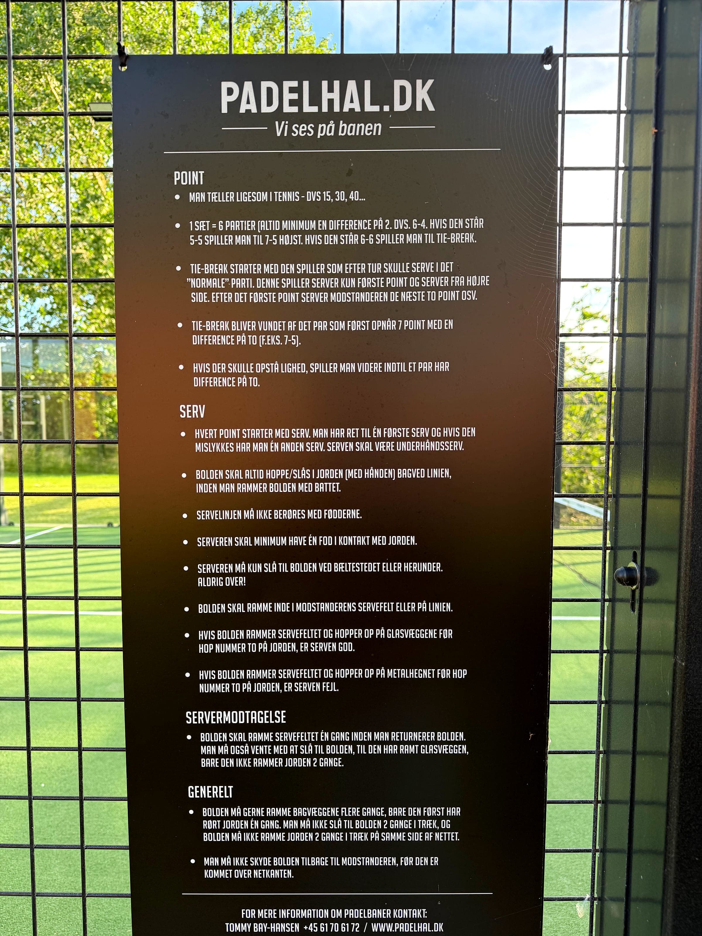 Skilt med spilleregler for padel opsat på hegnet