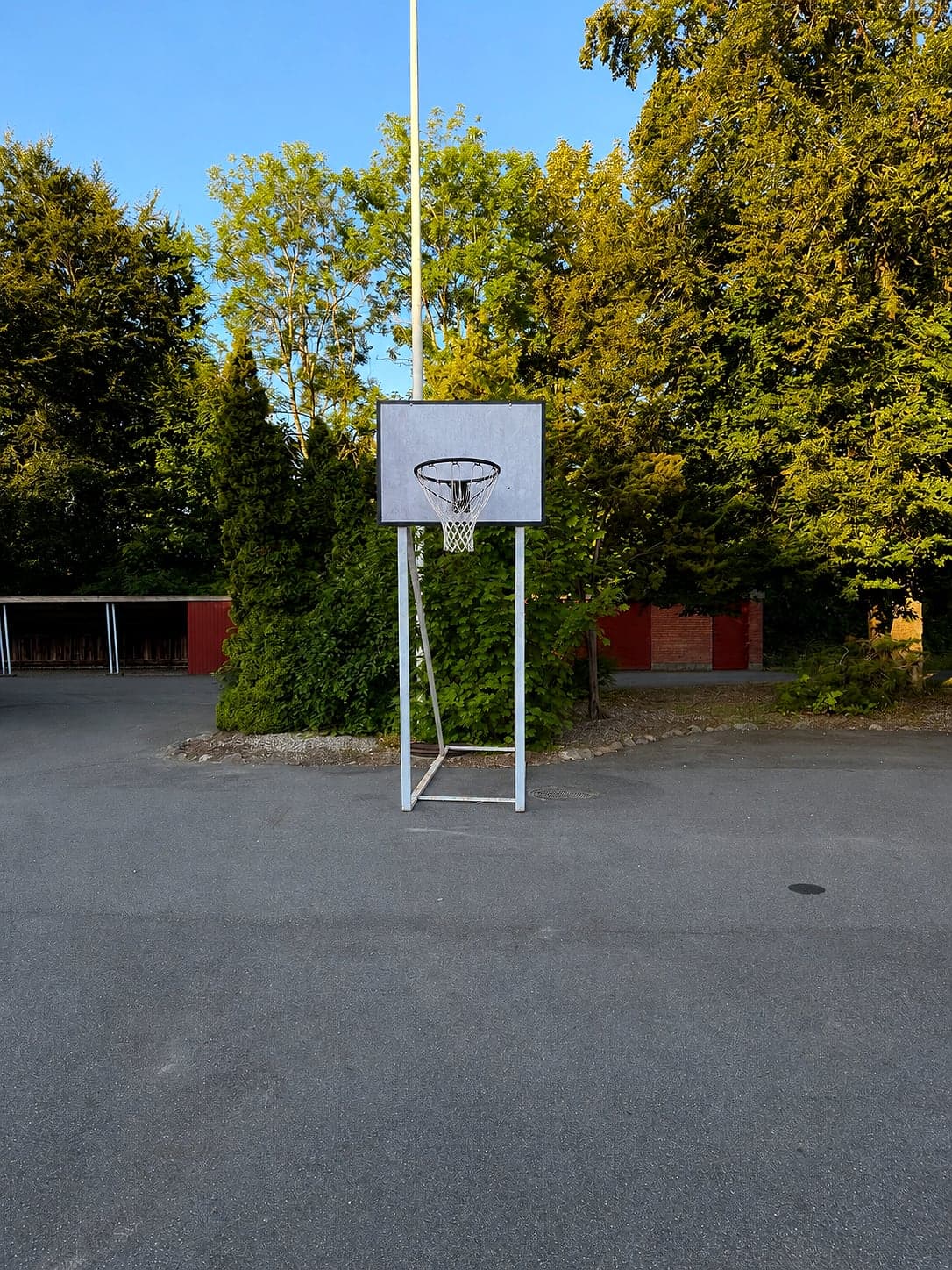 Basketballkurv på åben asfaltplads ved siden af Hou legeplads