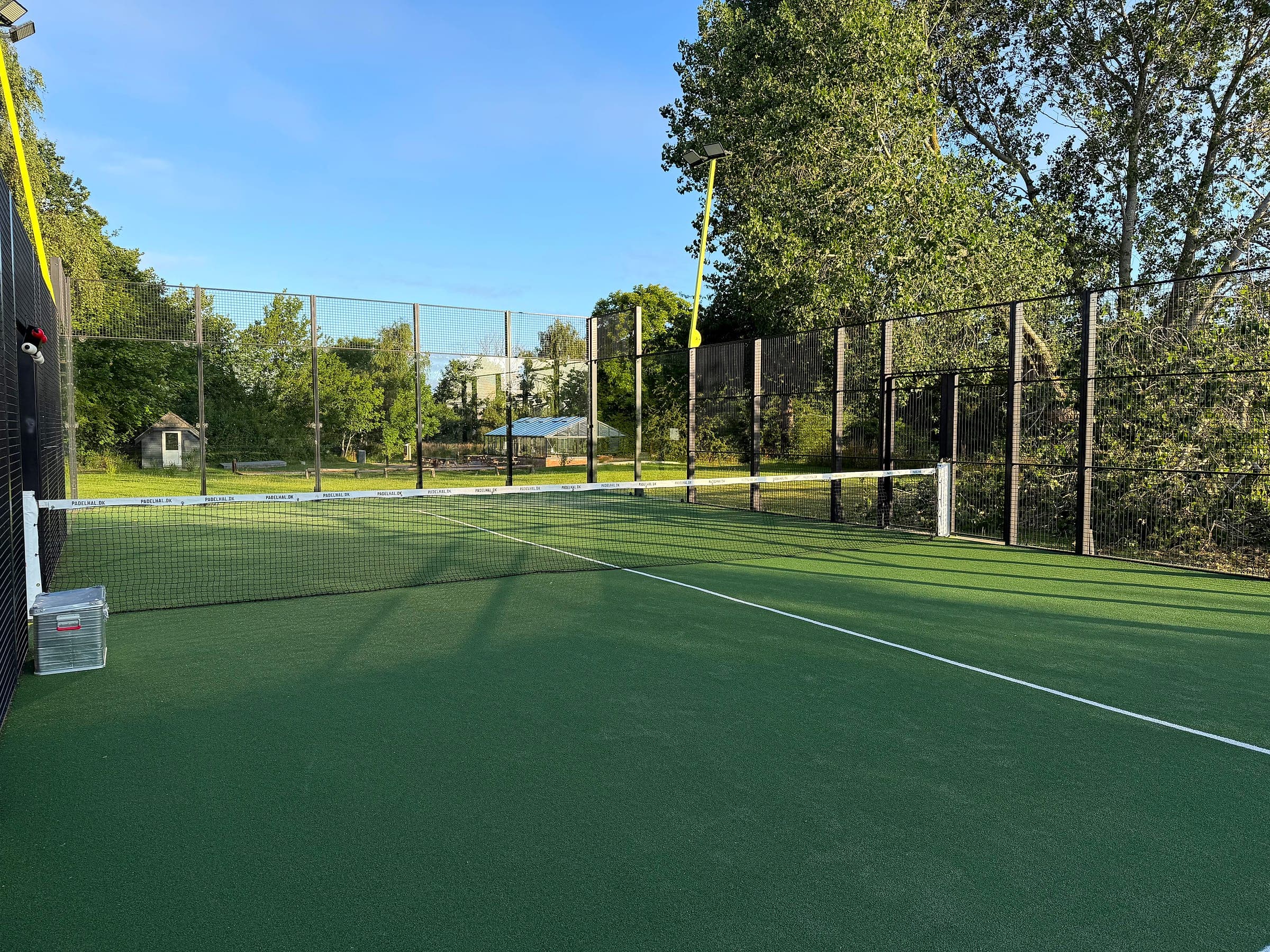 Udsigt hen over padelbanen med kunstgræs og hegn omkring